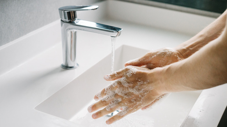 Man washing his hands in a bathroom
