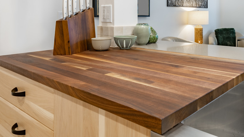 A sleek, modern butcher block counter in an open floorplan kitchen