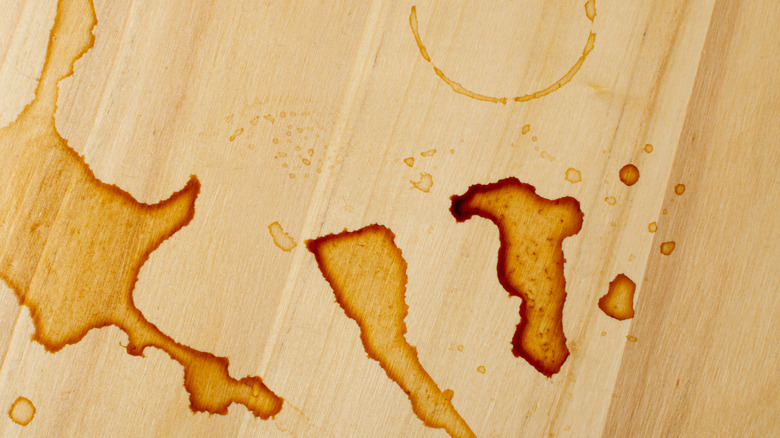 A close-up view of a spill and stain on a wooden kitchen countertop