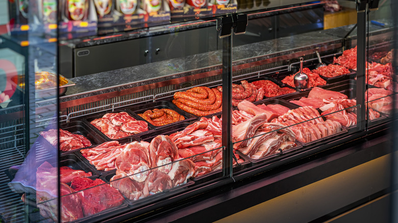 A butcher's display case full of different cuts of meat, ground meats, and sausages