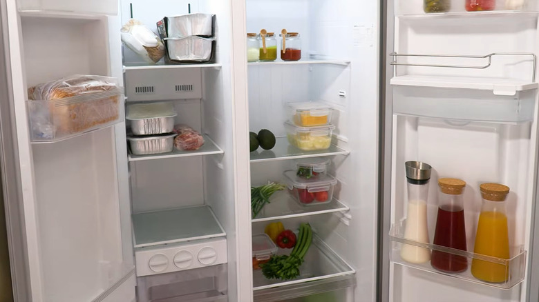An open side-by-side refrigerator packed full of groceries