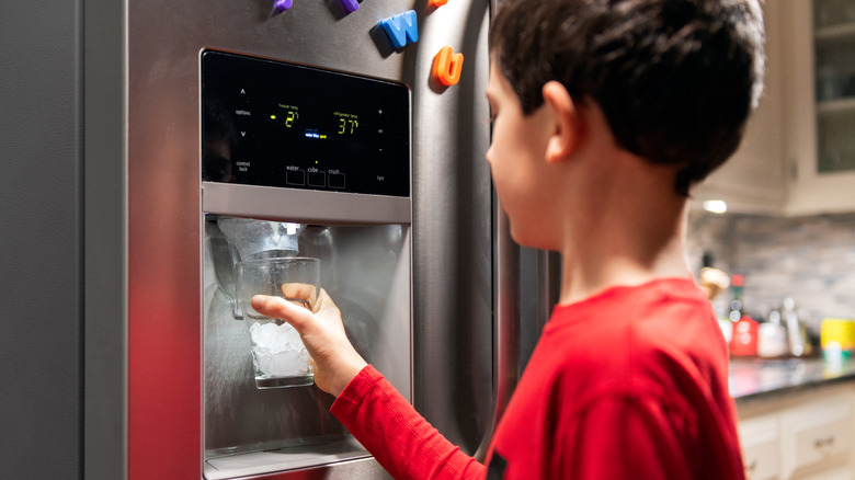 A child getting ice from an ice dispenser
