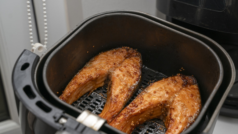Two portions of fish in an air fryer basket