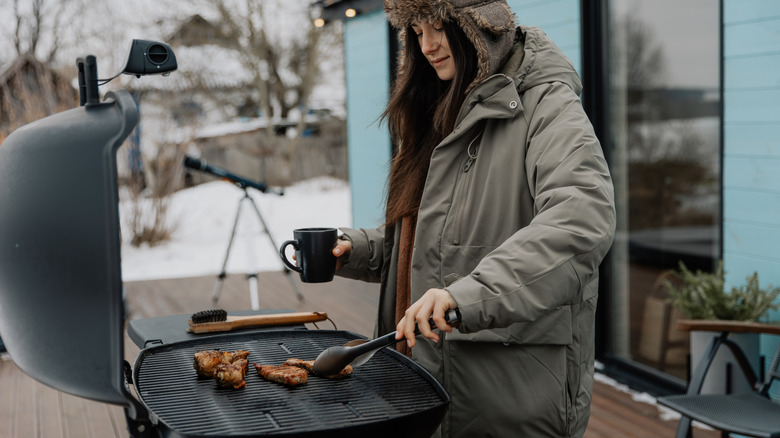 Woman grilling outdoors in winter