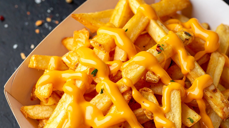 Paper container of fries covered in melted cheese