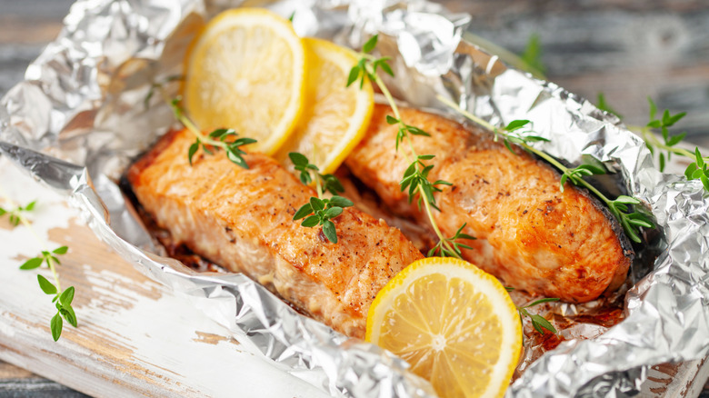 Salmon cooked in foil with lemon slices and thyme sprigs