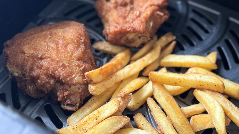 Fried chicken and french fries in an air fryer basket