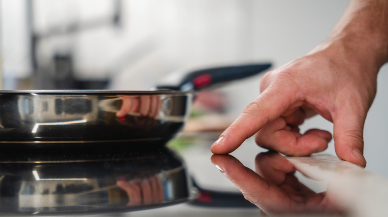 male turning on induction stove