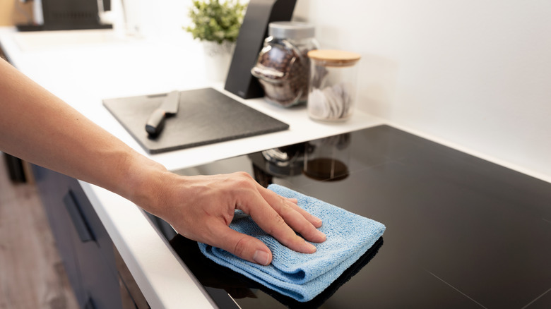 man cleaning induction stove