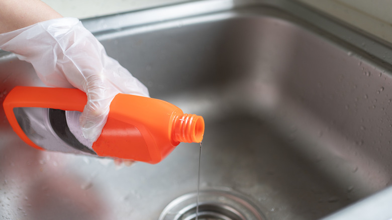 A person pouring drain cleaner down the sink