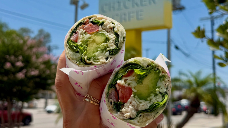 A hand holding two halves of a wrap.
