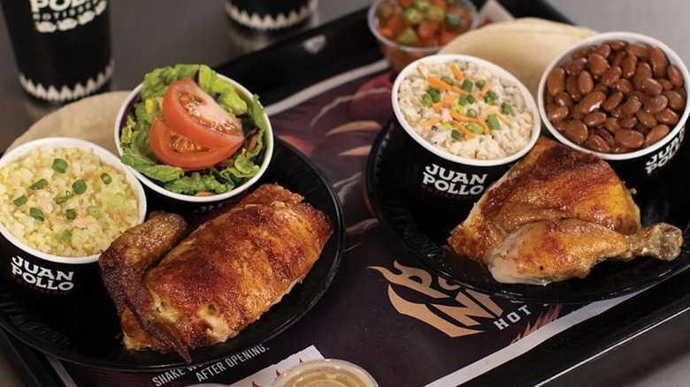 A tray of various food items in Juan Pollo containers.