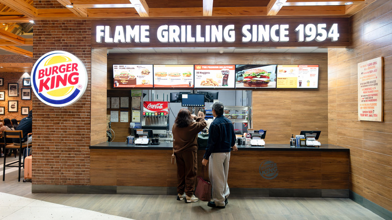 Customers standing at a Burger King checkout counter