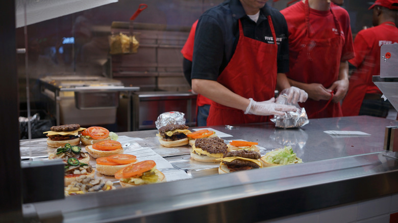 Five Guys workers preparing hamburgers