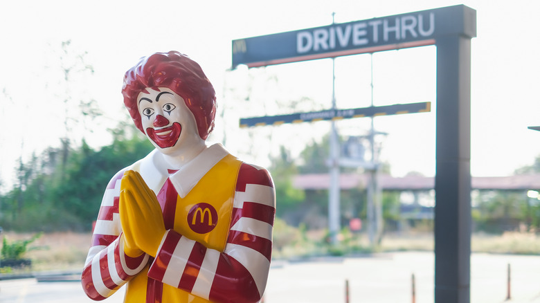 Ronald McDonald statue in front of a McDonald's drive thru