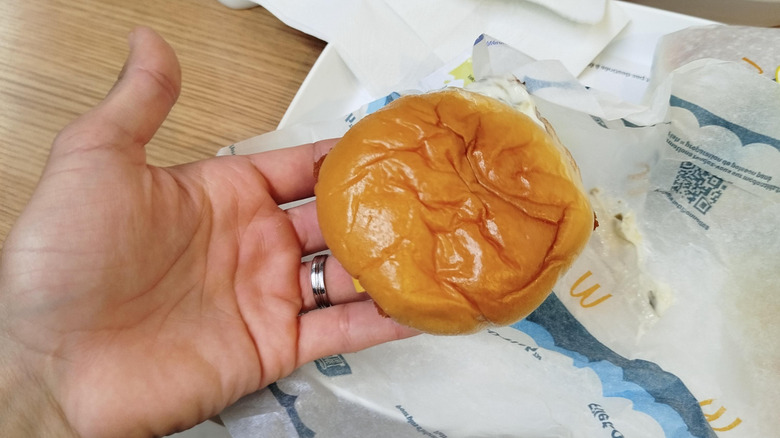 A hand holding a small Filet-O-Fish from McDonald's.