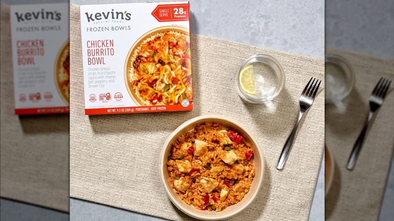 A box of Kevin's Natural Foods Frozen Chicken Burrito Bowl sitting on the counter next to it served in bowl