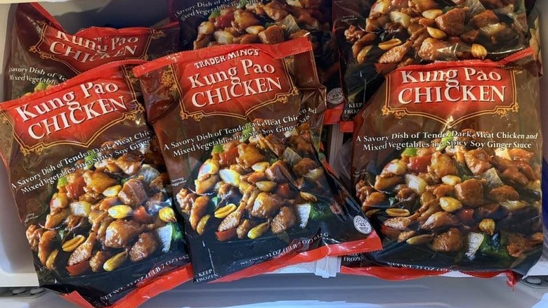 Three packages of Trader Joe's Kung Pao Chicken lined up in a freezer case