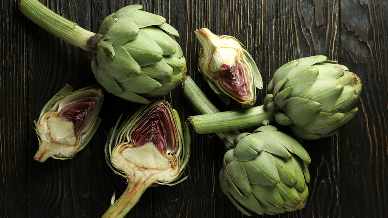 overhead view of whole and halved fresh artichokes