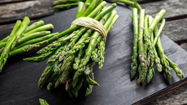 bunches of fresh asparagus on cutting board