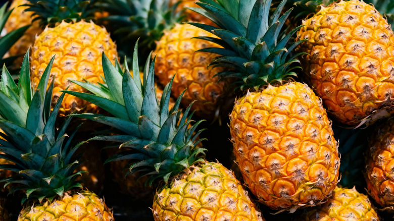 fresh pineapples displayed at market stall