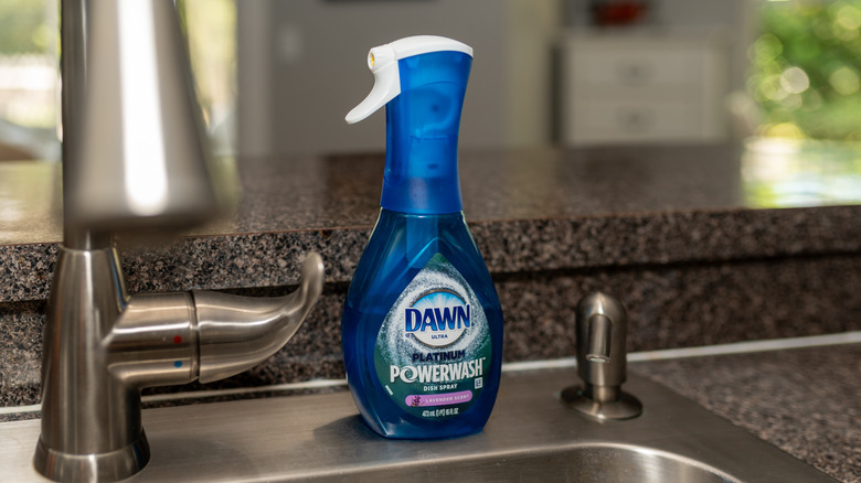 A bottle of Dawn Powerwash sitting next to a stainless steel sink in a kitchen
