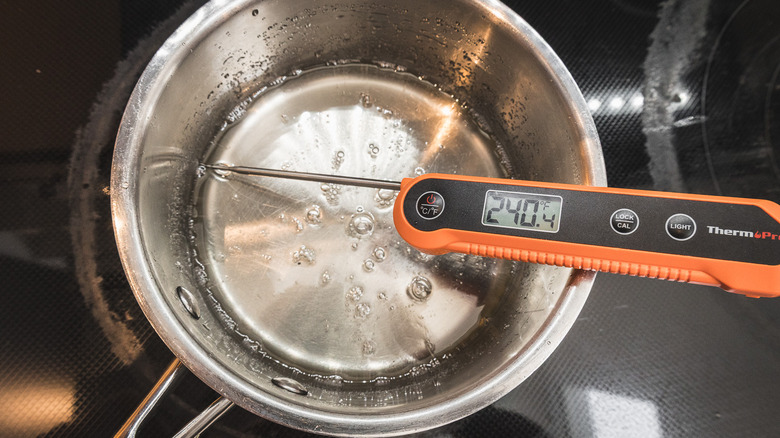 Sugar and water in saucepan with thermometer