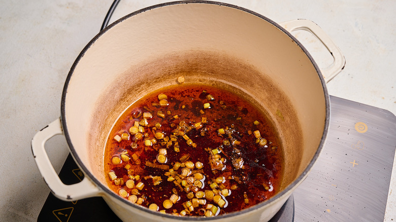 cooking soy sauce and chili oil with scallion