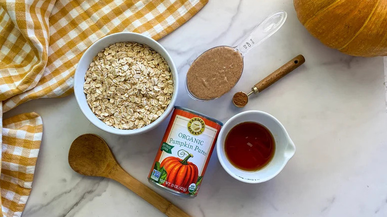 The five ingredients laid out for pumpkin cookies on a table.
