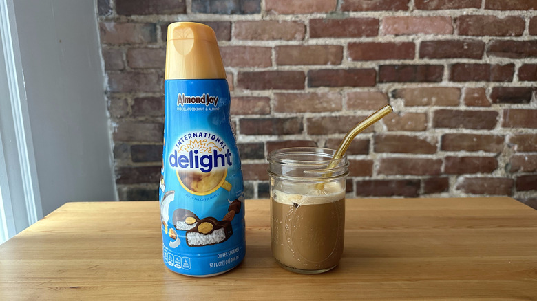 Almond Joy International Delight container next to an iced coffee