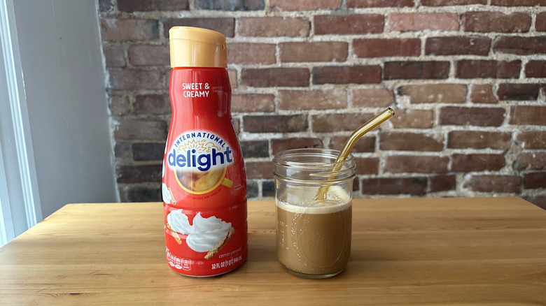 Sweet and Creamy International Delight container next to an iced coffee