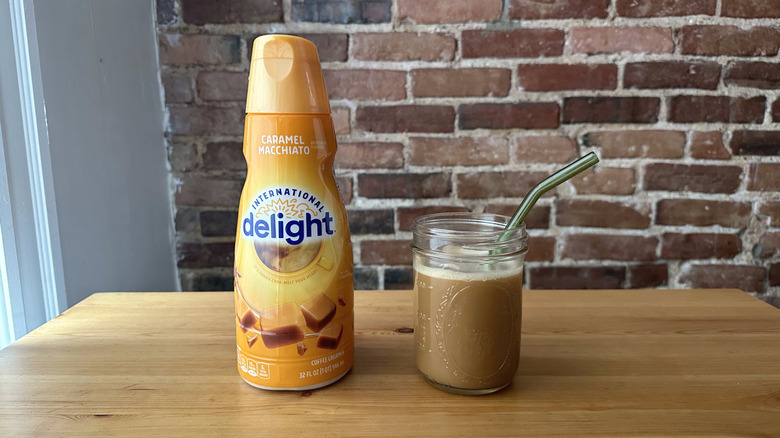 Caramel Macchiato International Delight container next to an iced coffee