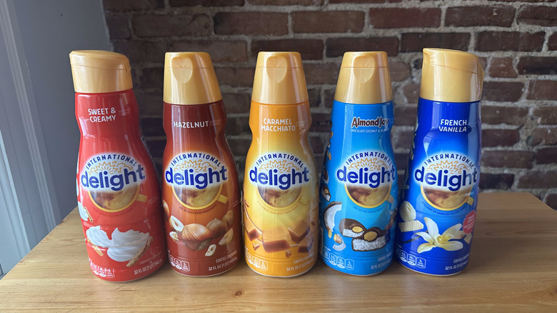 Five International Delight coffee creamers on wooden table