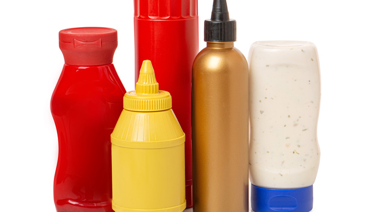 Several plastic condiment bottles against a white background