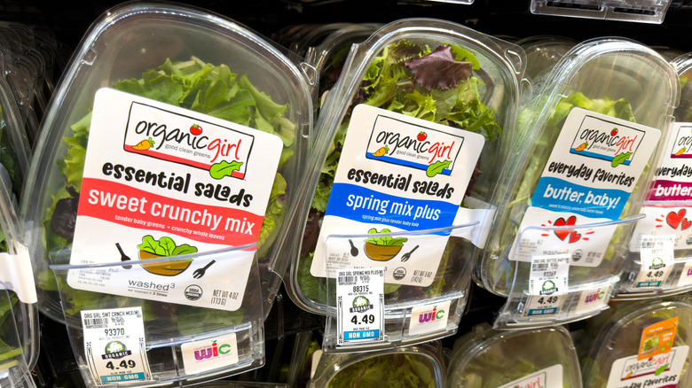 Several plastic tubs of Organicgirl green vegetable products on display inside store