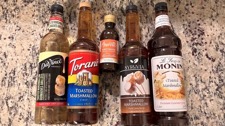 DaVinci Gourmet, Torani, Amoretti, Syruvia, and Monin toasted marshmallow syrups are next to each other on a countertop