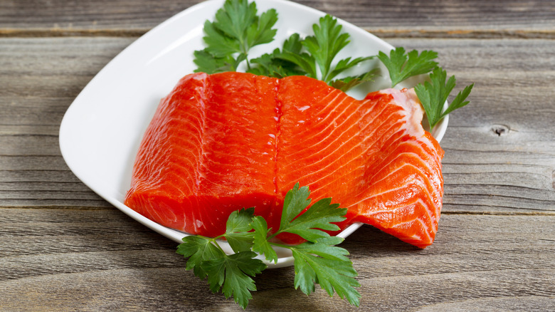 A sockeye salmon fillet on a plate with parsley