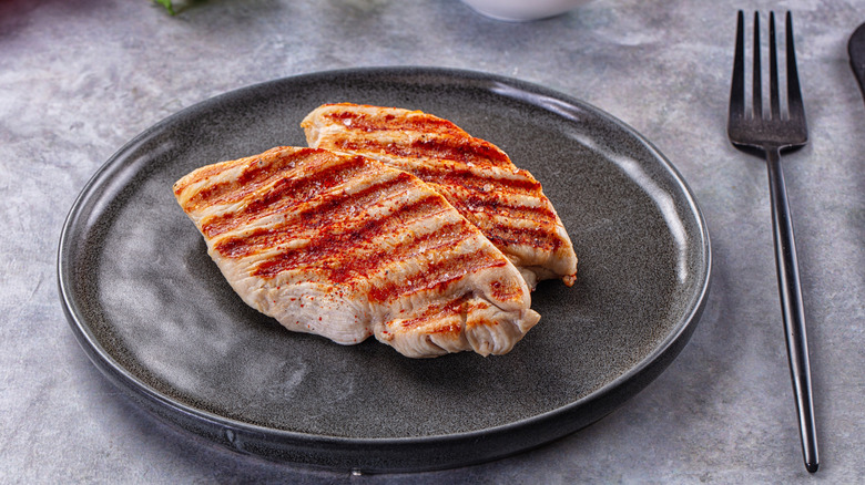 Two seasoned and grilled turkey breasts on a plate