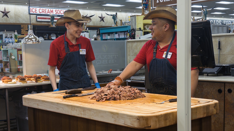 Buc-ee's employees preparing fresh brisket with brisket sandwiches already made in the background