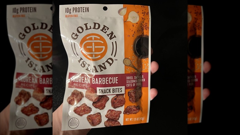A person holding up a bag of Golden Island Korean Barbecue Recipe Pork Snack Bites