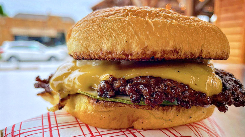 A cheeseburger from Archie's Flat Top sitting outside