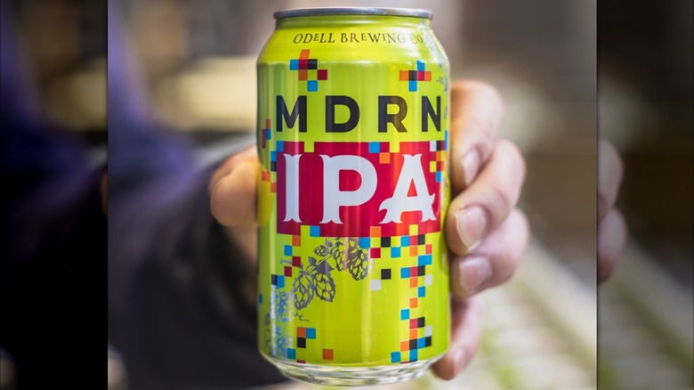 Hand holding a can of Odell Brewing's MDRN IPA