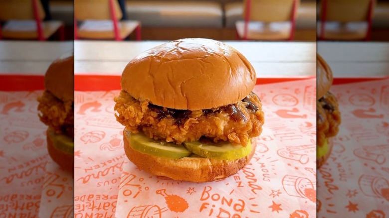 Popeyes Honey BBQ Chicken Sandwich sitting on tray with patterned paper placemat