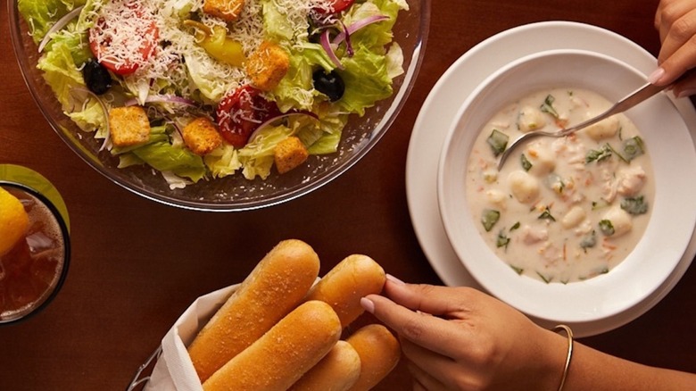 aerial image of woman eating breadsticks, soup, and salad from Olive Garden