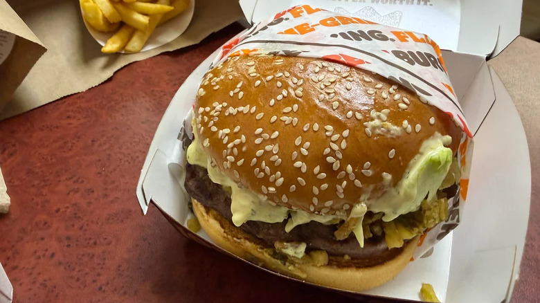 The Loaded Jalapeño Whopper half-wrapped in its cardboard serving container