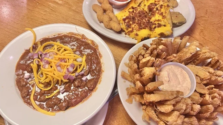 Potato skins, chili, and a Cactus Blossom from Texas Roadhouse sitting on a table