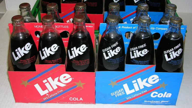 Glass bottles of Like Cola soda in red and blue cardboard carriers