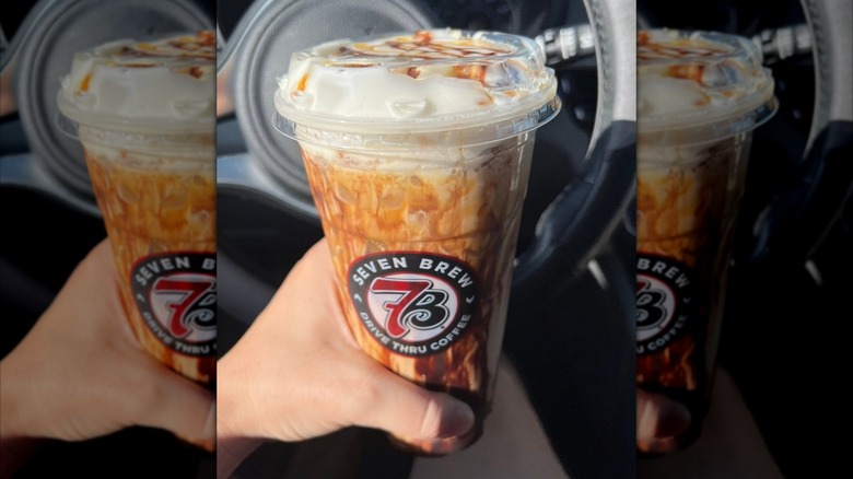 Hand holding cookie butter Blondie iced coffee drink from 7 Brew Coffee