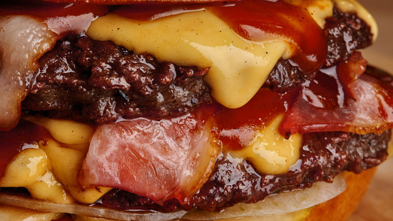 close up of bacon, beef, and cheddar on a sandwich