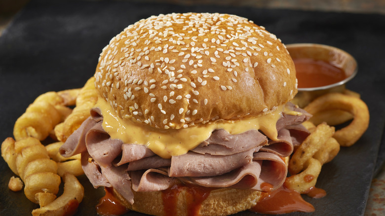 Arby's Beef and Cheddar sandwich on a sesame seed bun with Arby-Q sauce and a side of curly fries